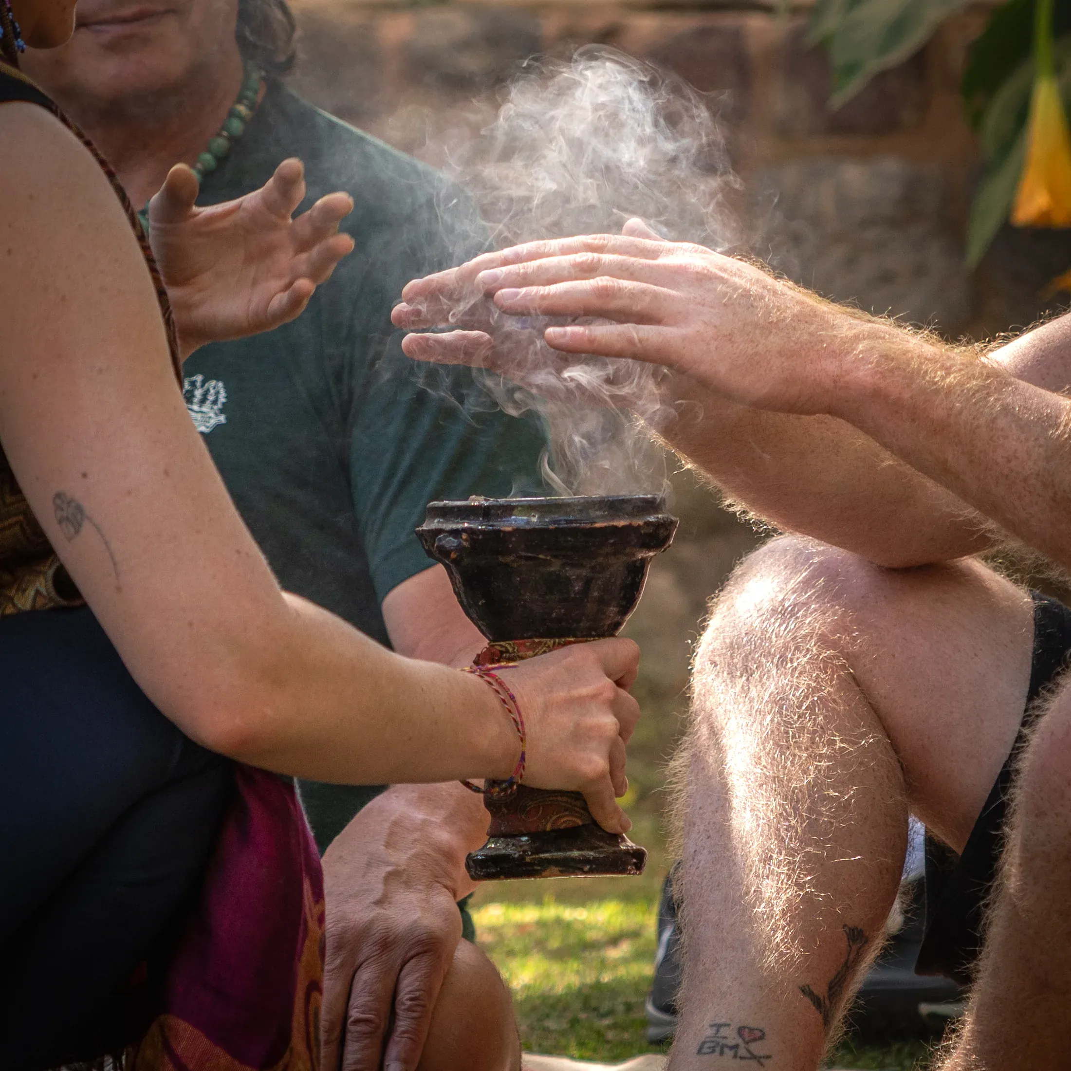 Hands drawing smoke from a clay censer