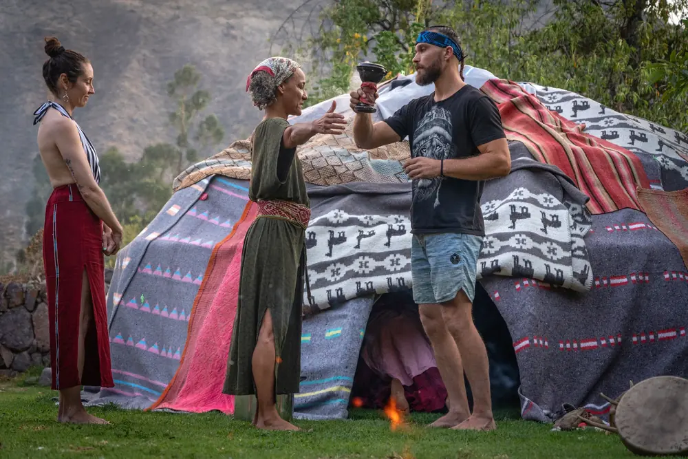 Participants share a blessing in front of the blanket-covered sweat lodge